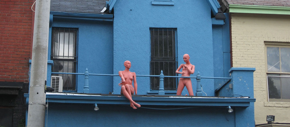 A picture of two mannequins on a balcony.
